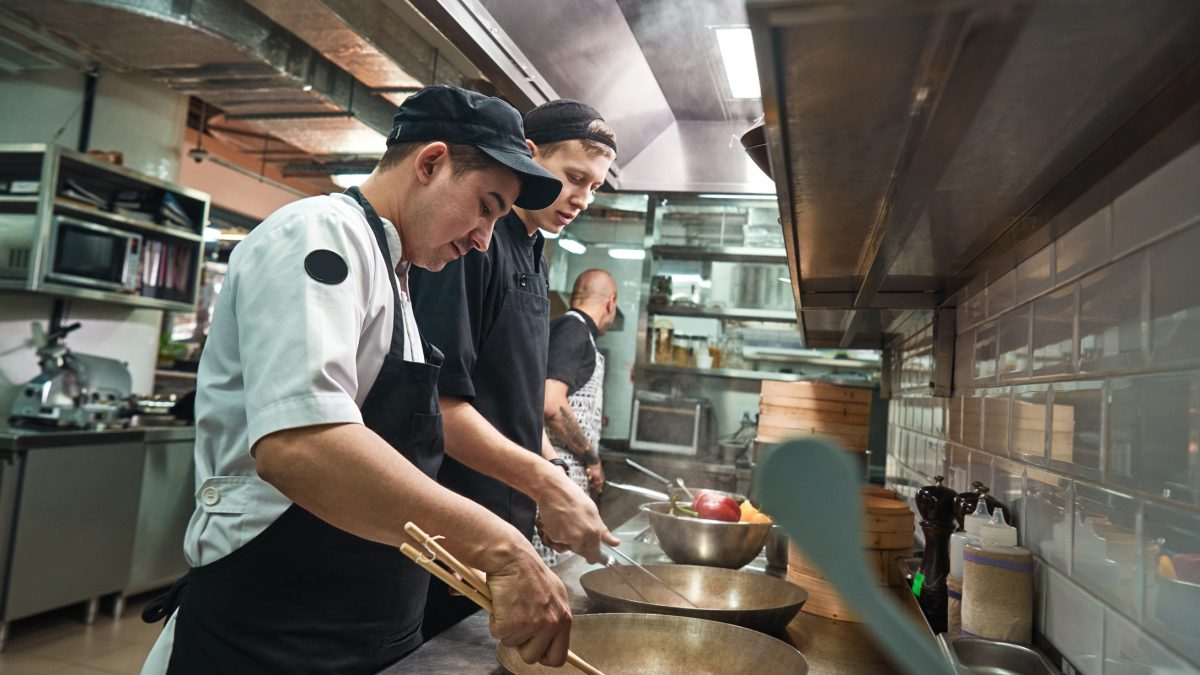 Junge Köche in einer Restaurantküche bei der Arbeit